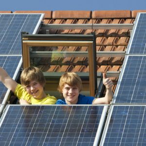 Kinder in Dachfenster mit Solarplatten
